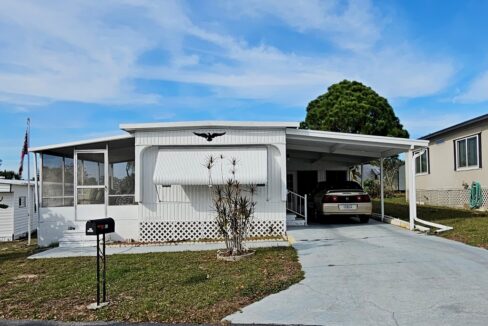 You'll love this location at 102 Baywood DR, E, Dundee, FL. White single-wide mobile home with side lanai, driveway to attached carport, awning over front window