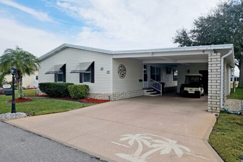 You belong here in this beautiful home at 1614 Glen Abby LN, Winter Haven, Florida. Double-wide manufactured home with deco driveway, beige vinyl siding, wide carport