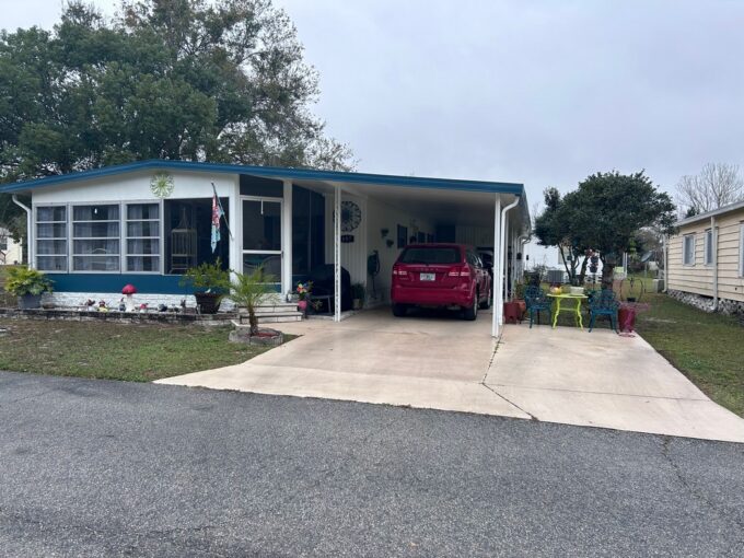 Double-wide manufactured home at 3150 NE 36th AV #497, Ocala, FL. White with Blue Trim. Make this beauty yours!