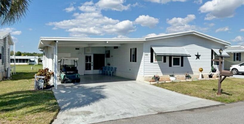 210 Fairview CIR double-wide Homes of Merit double-wide. White with wide driveway and carport...a Golfer Paradise and Entertaining Dream.