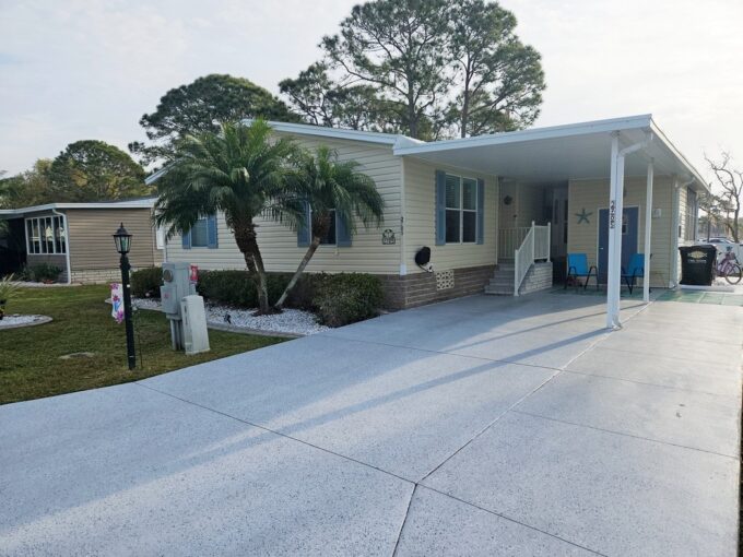 Leisure Living: Joyful Retirement Lifestyle begins owning this beautiful home at 2705 Alcott Dr, Lake Wales, FL. Cream colored vinyl siding, extra wide driveway, blue shutters