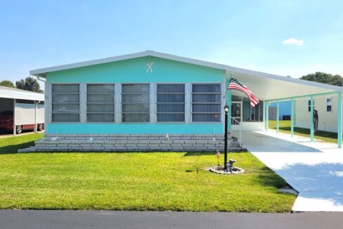 The Teal and white double-wide with large carport and deco driveway will offer an effortless move-in since it is fully furnished and ready.