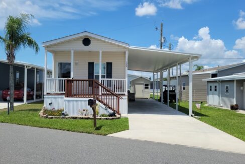 172 Valencia in Winter Haven community of Orange Manor East. Single wide 960 sq ft, yellow vinyl siding home with open front porch, carport, gutters, private driveway and curb side mail delivery.