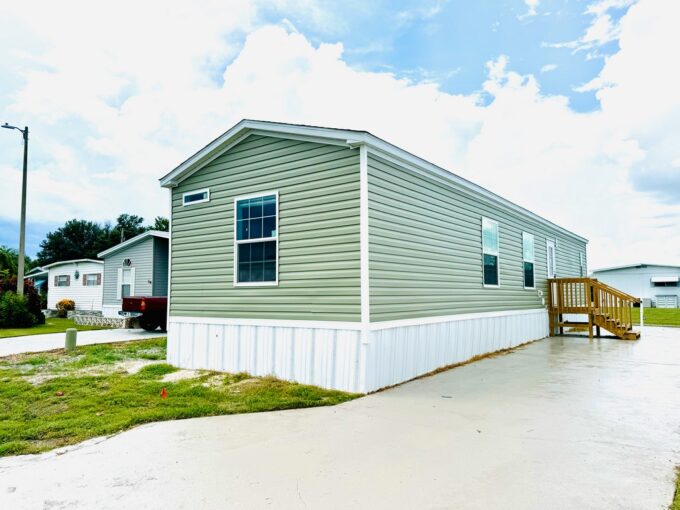 Exterior view of home before carport is installed, green vinyl with white vinyl skirting.