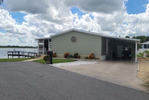 116 King Drive in Orange Manor East in Winter Haven, Waterfront with your private dock, vinyl siding, private oversized driveway with carport, storage shed, gutters,