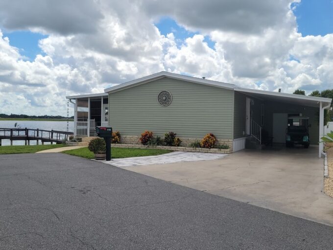 116 King Drive in Orange Manor East in Winter Haven, Waterfront with your private dock, vinyl siding, private oversized driveway with carport, storage shed, gutters,