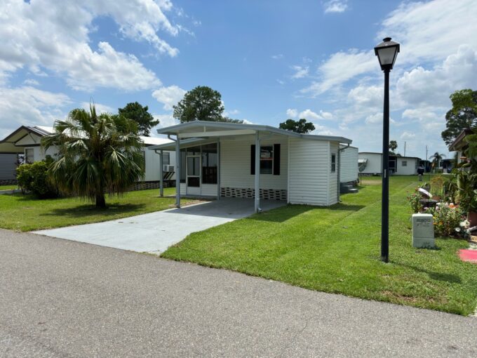 Single wide home with 1 bedroom and 1 bath, private driveway, gutters, 2 sheds, and a lanai.