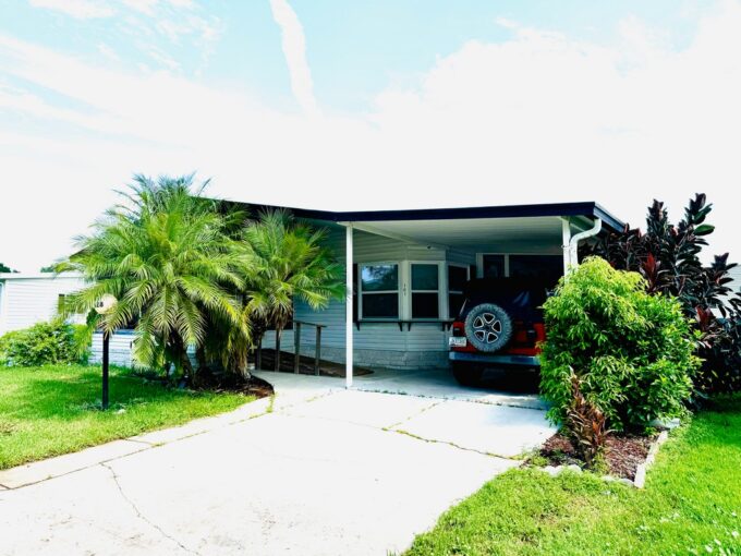 View 2 - Two bedroom 2 bathrooms home with ramp, carport, lanai, screened porch, shed, gutters, private driveway.