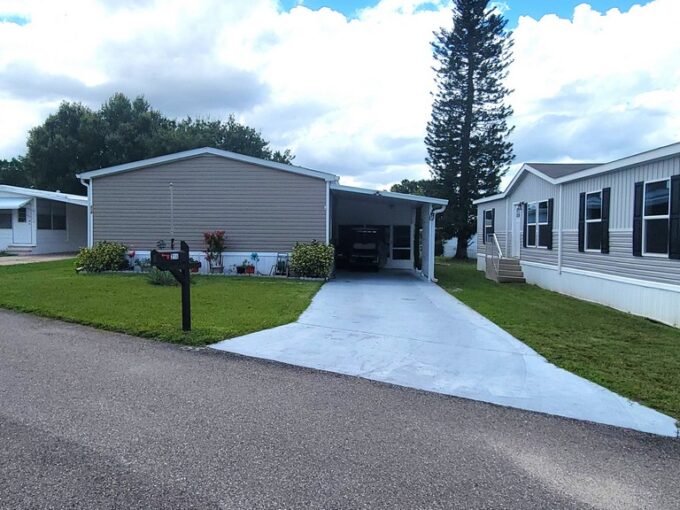 214 Green Haven Lane West in Dundee located in Dell Lake Village Community. Partially furnished, tan vinyl siding, 3 bedroom home, with carport, private driveway, curbside mail delivery.