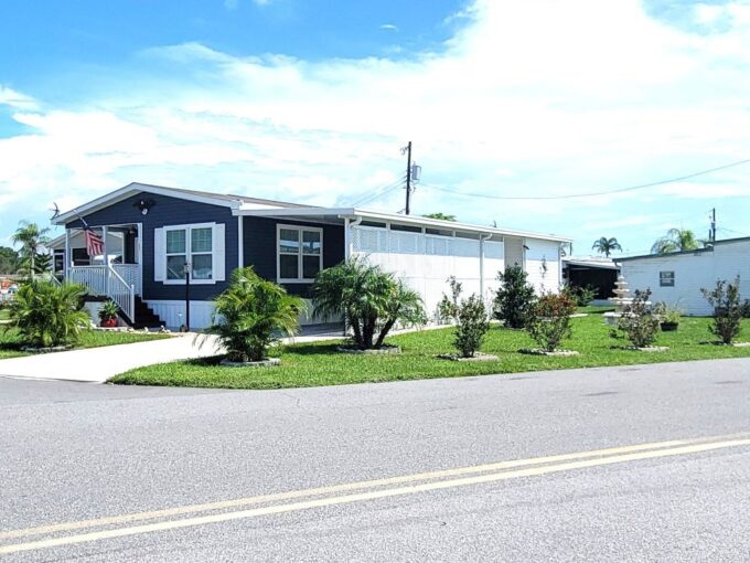 This home sits on a corner lot close to the clubhouse, private drive way, curbside mail delivery, carport, storage shed with work bench, open porch, beautiful modern blue siding with white trim.