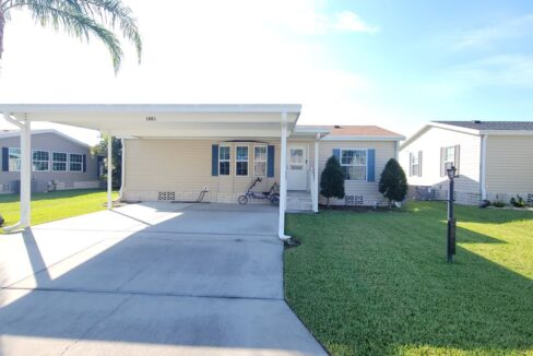 Vinyl siding home with private driveway, carport, gutters, back lanai, two bed, two bath.