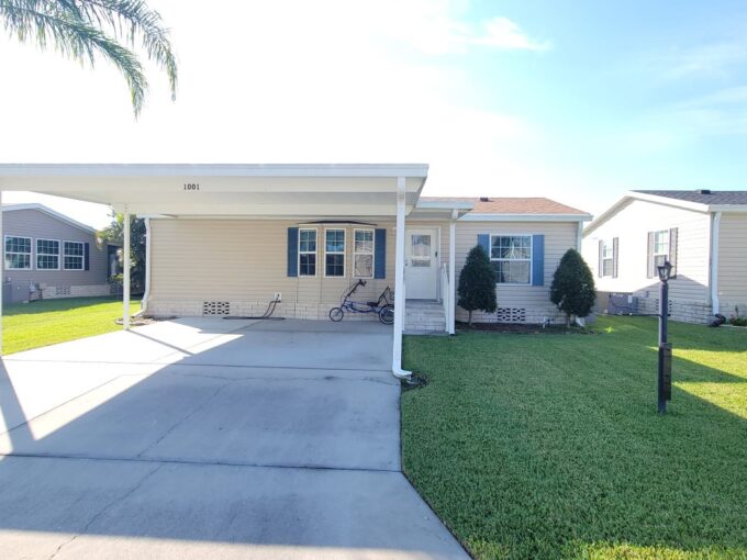 Vinyl siding home with private driveway, carport, gutters, back lanai, two bed, two bath.