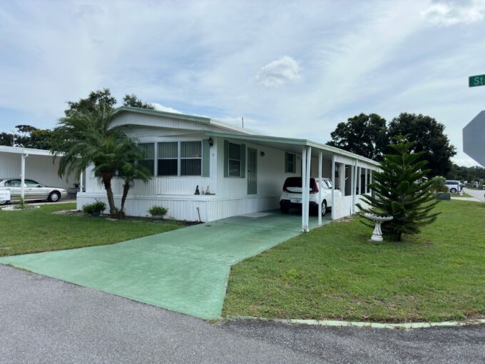 1344 sq ft, corner lot, white siding, green accents, private driveway, carport, curb side mail delivery, gutters, awnings on some of the windows.