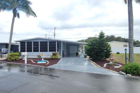 Water view home with private driveway, carport, gutters, storage shed 12x16, front lanai 10 x 20.