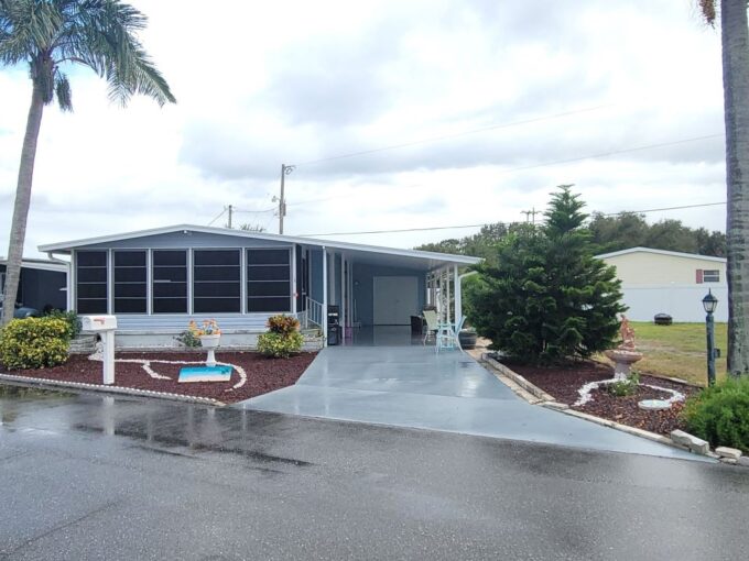 Water view home with private driveway, carport, gutters, storage shed 12x16, front lanai 10 x 20.