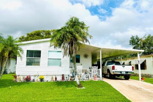 Aluminum siding home with 1104 sq ft of living space, front 4 season room, carport, private driveway, gutters, patio, storage shed, manicured yard.