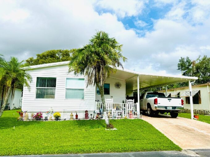 Aluminum siding home with 1104 sq ft of living space, front 4 season room, carport, private driveway, gutters, patio, storage shed, manicured yard.