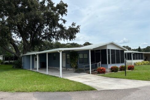 Two bedroom home on a corner lot in a gated community. Private driveway, carport, gutters, front lanai, storage shed.