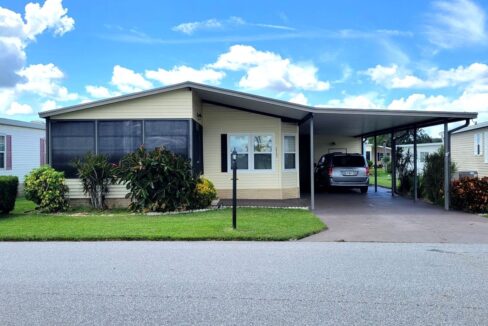 Front lanai, carport, private driveway, gutters, storage shed, workshop, with a water view.