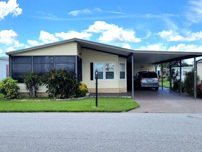 Front lanai, carport, private driveway, gutters, storage shed, workshop, with a water view.