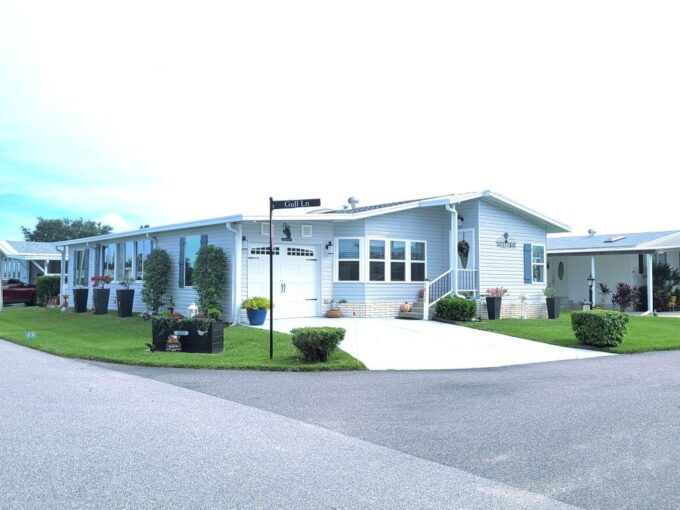 beautifully UPGRADED 1992 Home of Merit DOUBLEWIDE…located on a prime CORNER LOT with stunning WATER VIEWS…just steps away from the community POOL…CLUBHOUSE…FITNESS CENTER…and more. Everything you need is right at your fingertips….with garage, shed, patio, quartz countertops, ceramic tile throughout, New roof, new tankless water heater, newer central air unit.