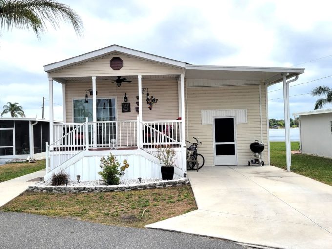 View of side entrance to home with steps and sidewalk leading to the front porch with dual steps. Vinyl Siding, shed and workshop on left side of home.